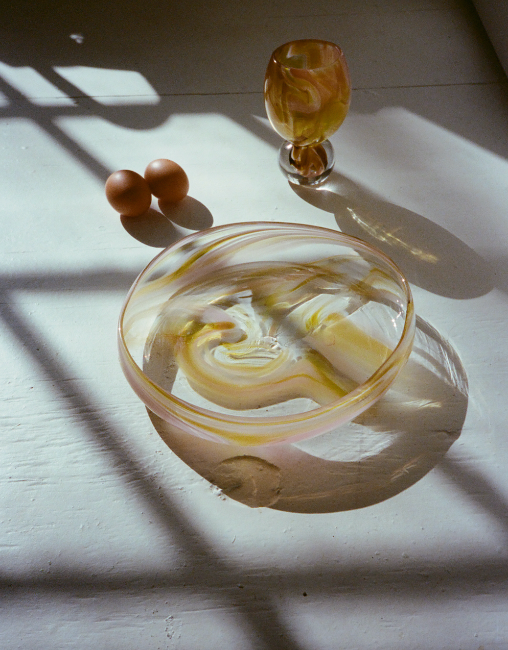 yellow and pink platter and coupe glass on table